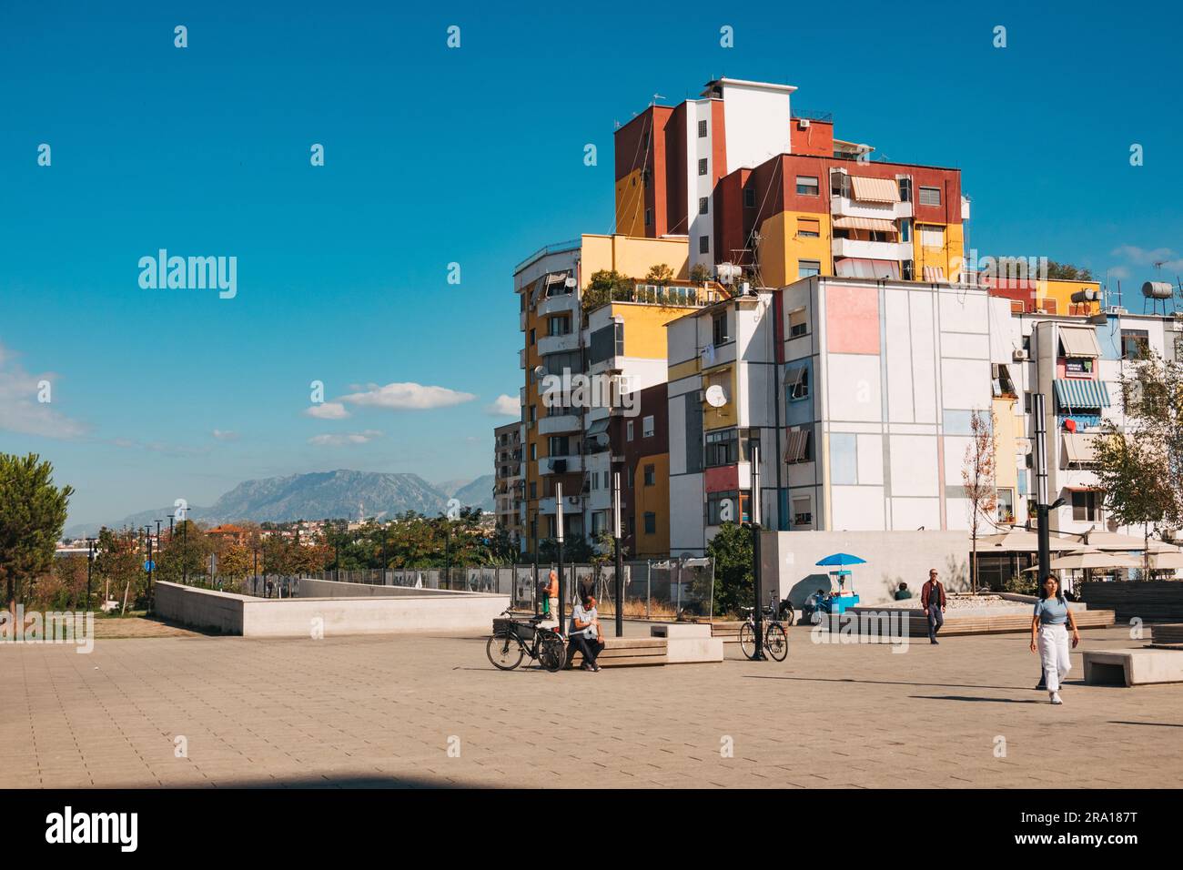 a multi-colored apartment building with a Mondrian mural on the side of it in Tirana, Albania Stock Photo