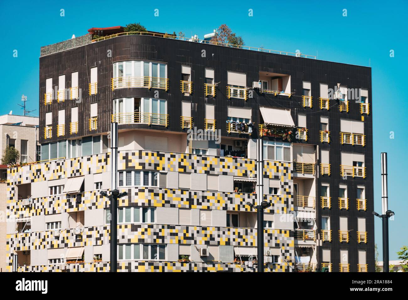 a modern apartment building in Tirana, Albania, with a colorful yellow, white, and grey tile