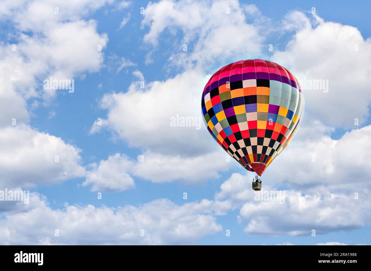 Colorful hot air balloon flying over blue sky with white clouds Stock ...