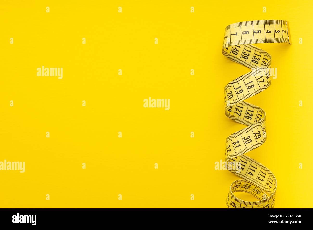 https://c8.alamy.com/comp/2RA1CW8/yellow-measuring-tape-on-the-yellow-background-top-view-2RA1CW8.jpg