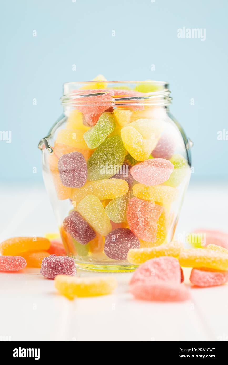 Mix of fruity jelly candy in jar on the white table. Stock Photo