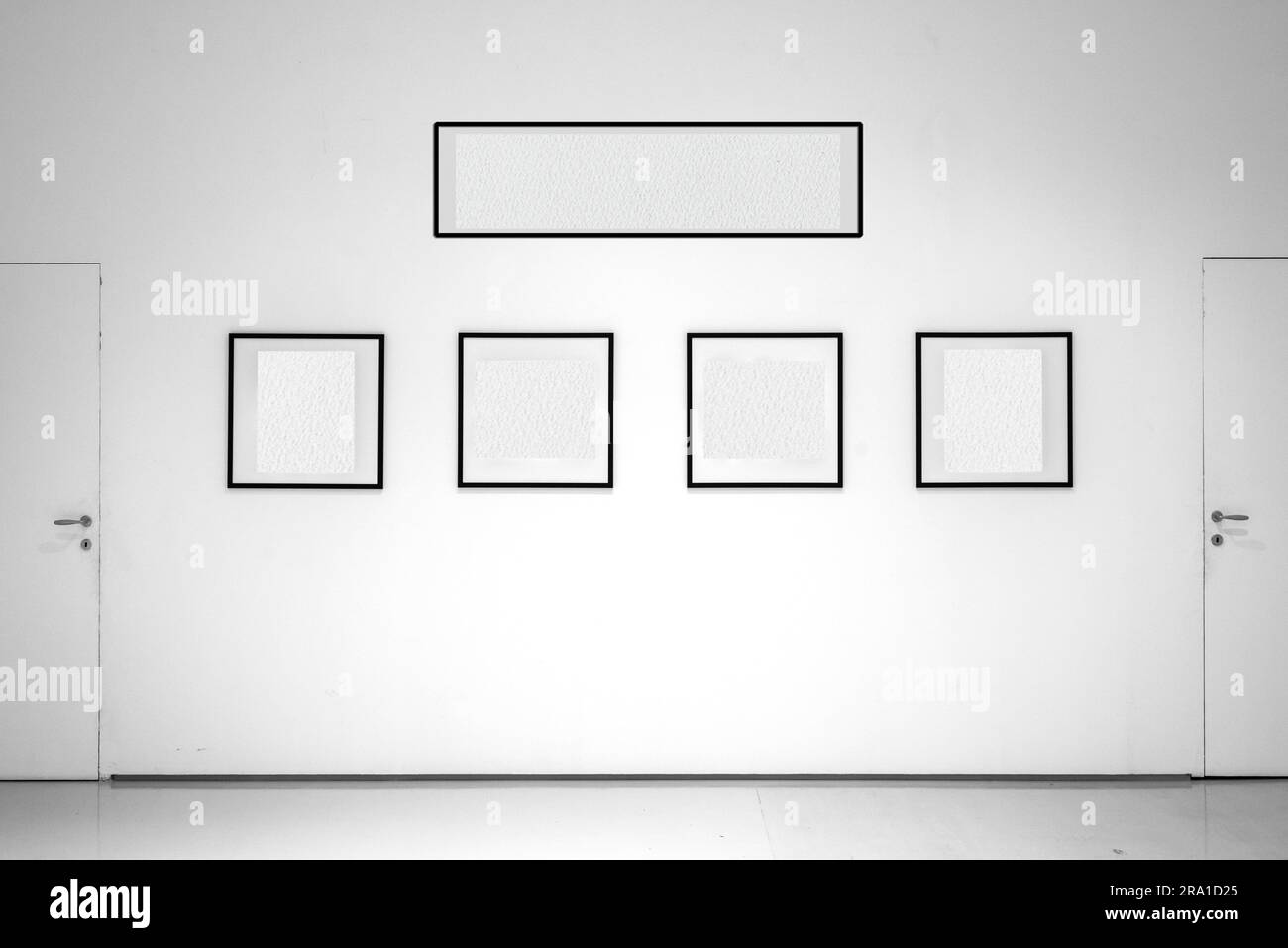 In the whitewalled showroom, frames with empty interiors are exhibited