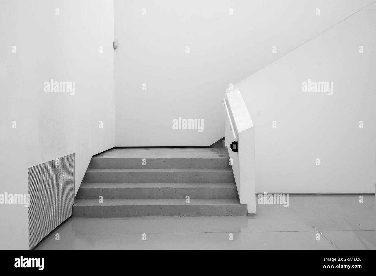 Architecture. White room interior. Empty ambient background. White walls with gray staircase. Stock Photo