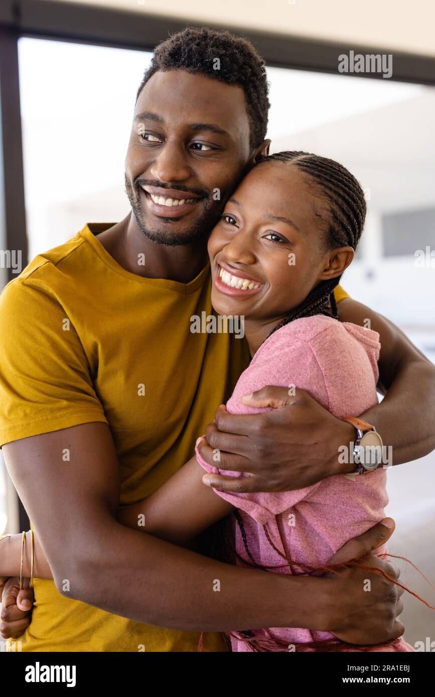 Happy african american couple hugging in living room Stock Photo - Alamy
