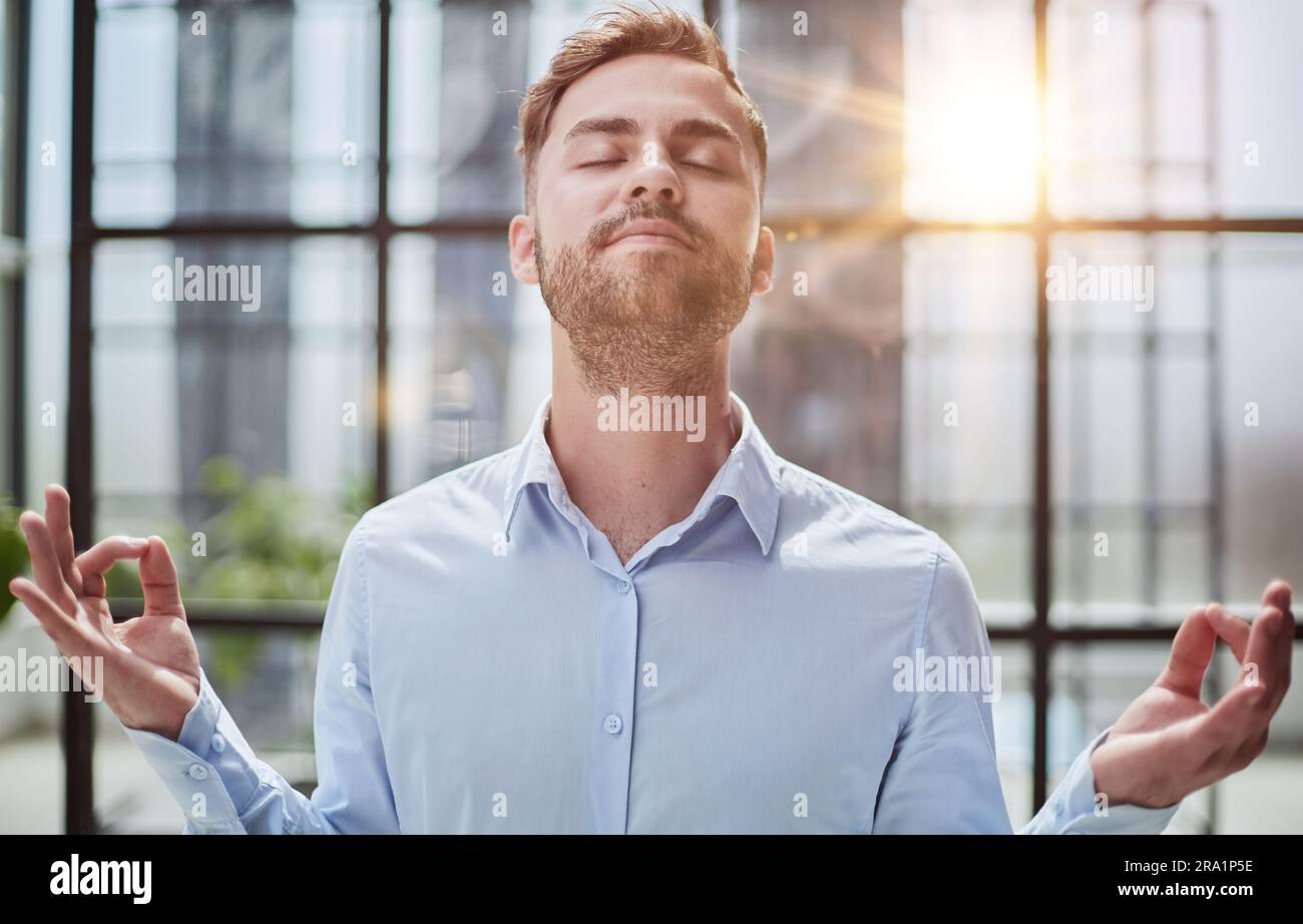 Young businessman relaxing while standing in the office Stock Photo