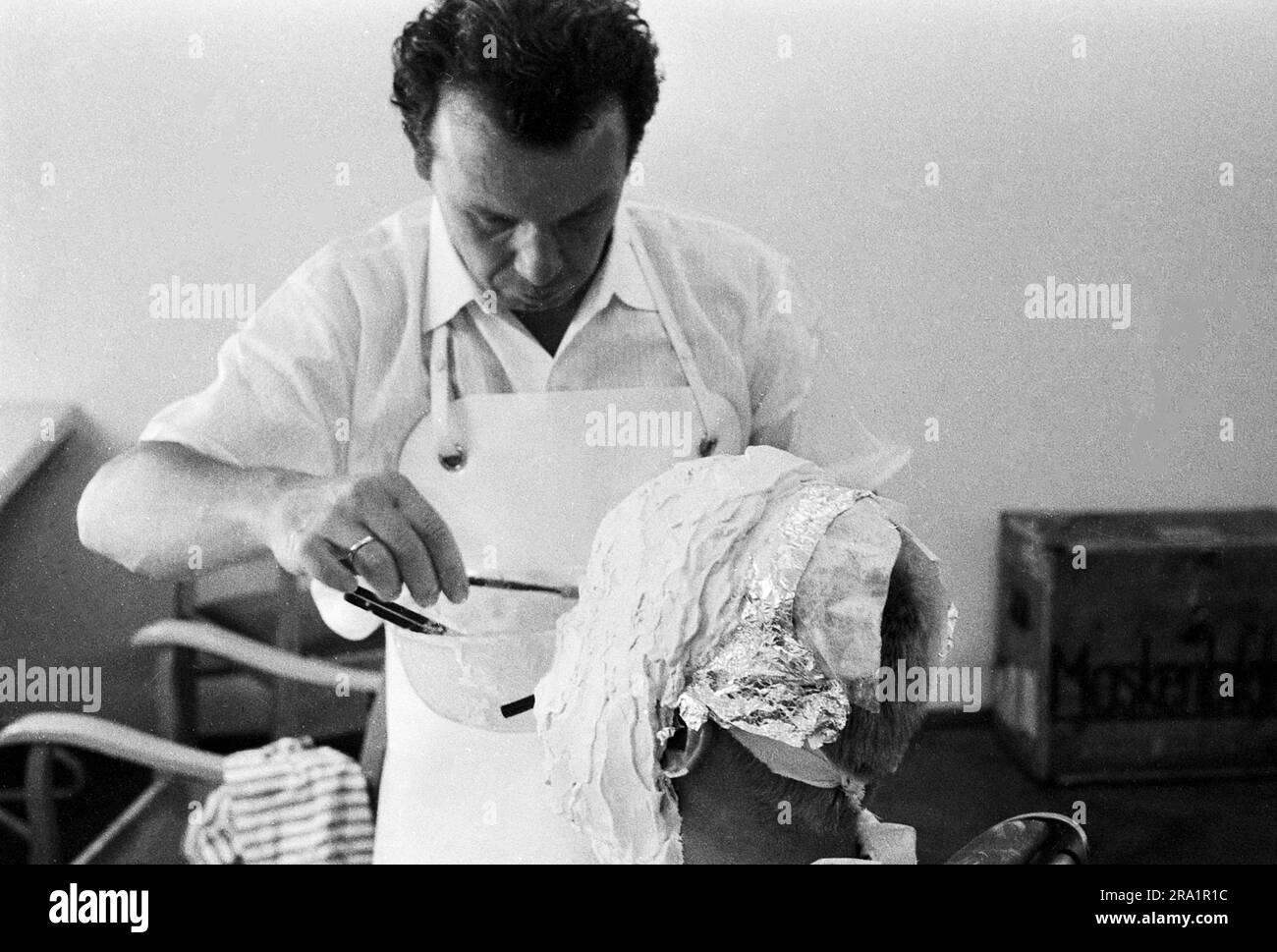 Nachts wenn der Teufel kam, Spielfilm, Deutschland 1957, Regie: Robert Siodmak, Darsteller Mario Adorf bekommt von Maskenbildner Franz Göbel die Gipsmaske abgenommen. Stock Photo