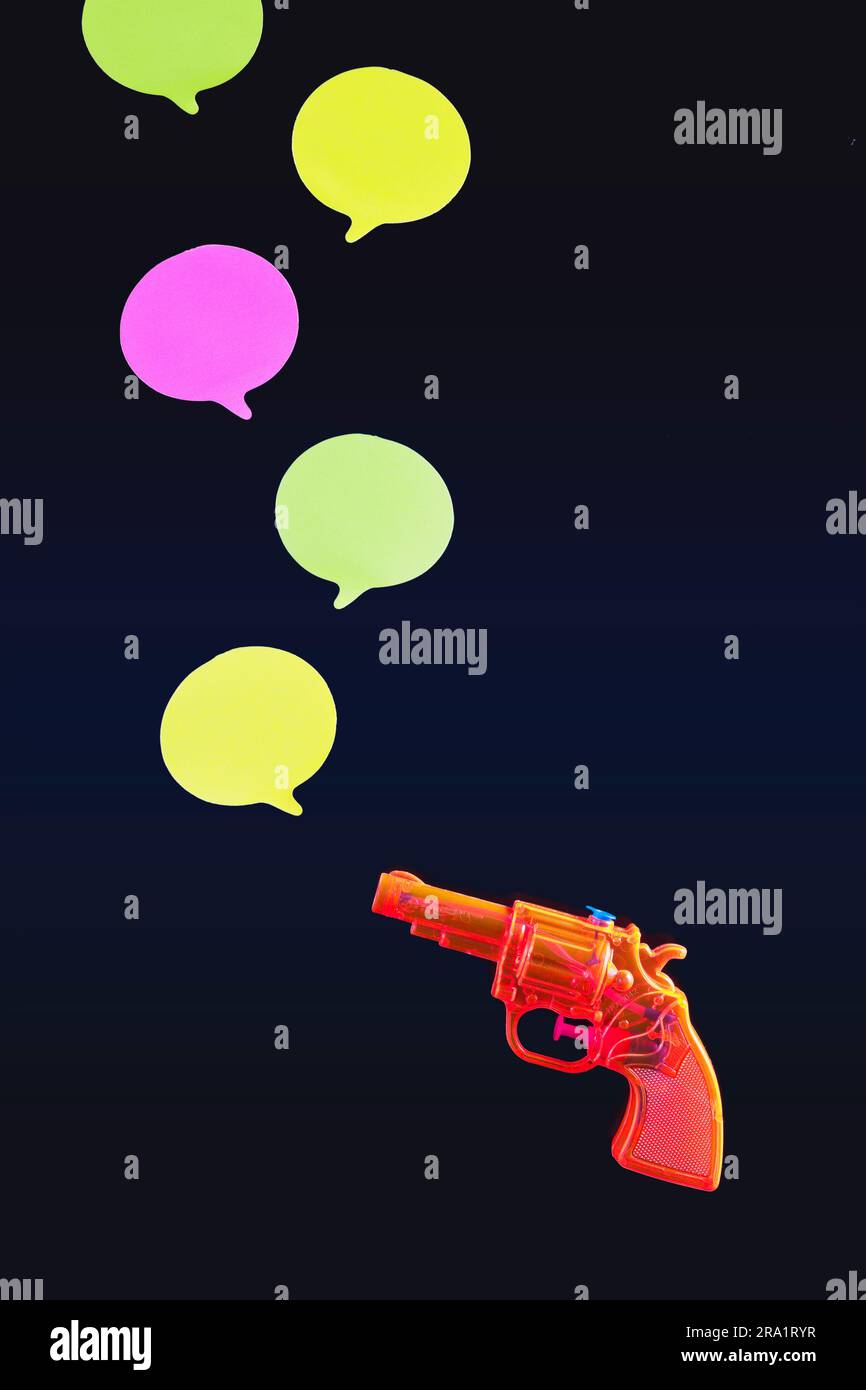 A toy gun shoots symbolic speech bubbles Stock Photo Alamy