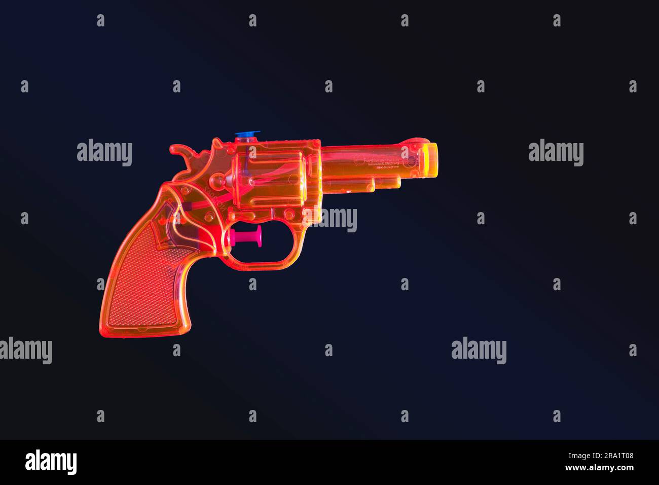 Cut out of an orange toy gun against black Stock Photo