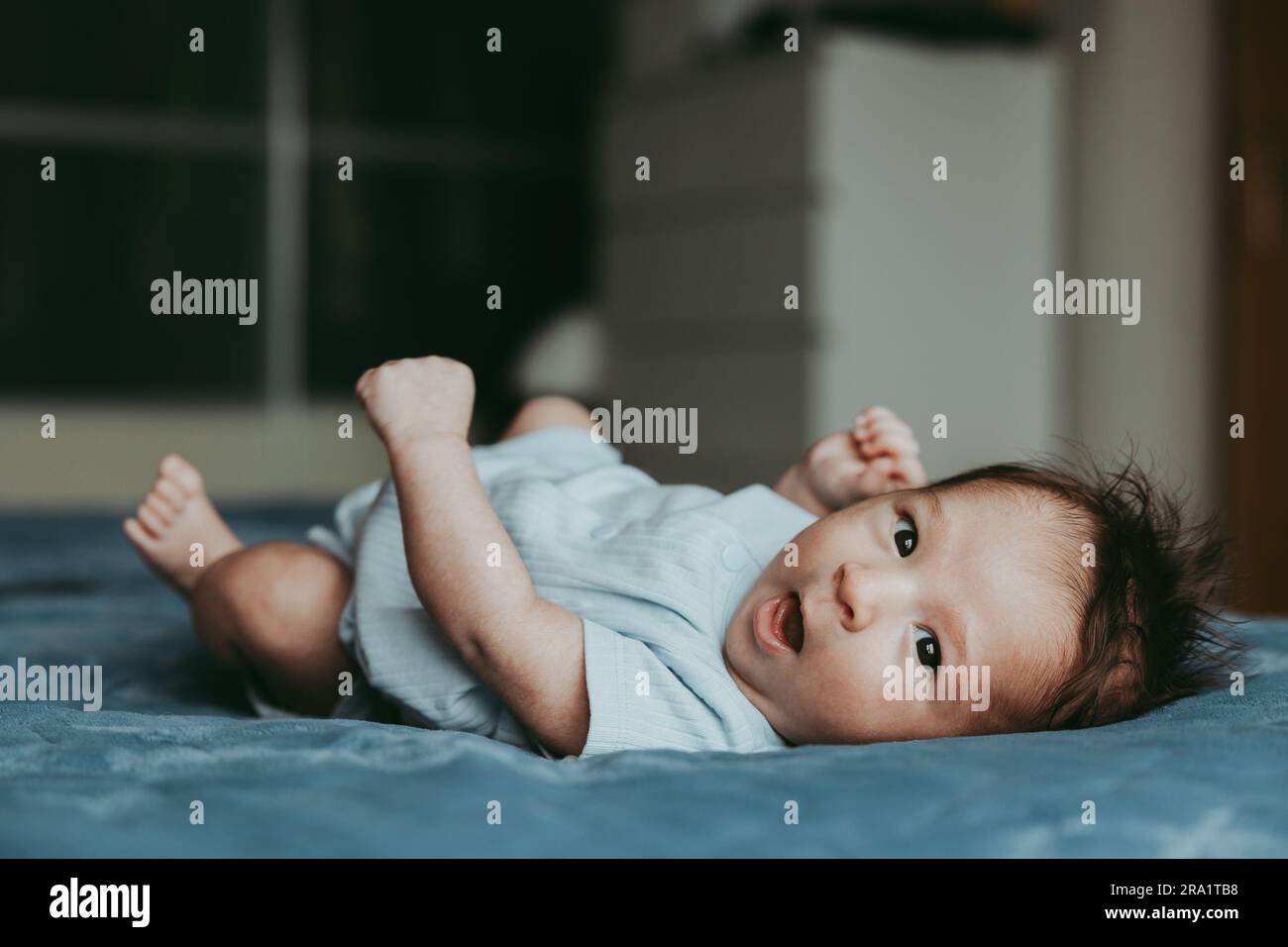 Baby lying on the back of the bed in a good mood Stock Photo Alamy