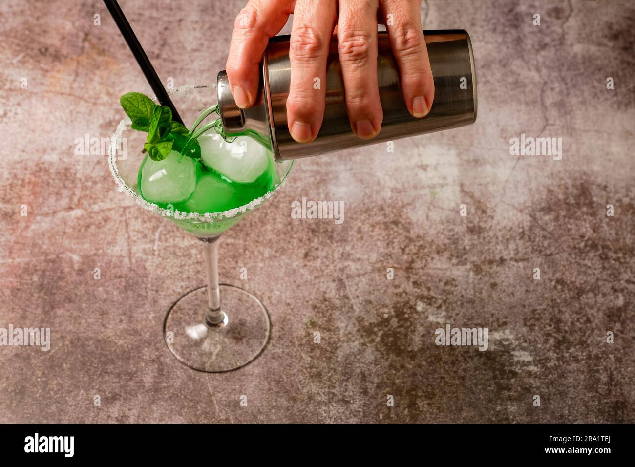 woman serving a mint cocktail with ice straw and mint leaves Stock Photo