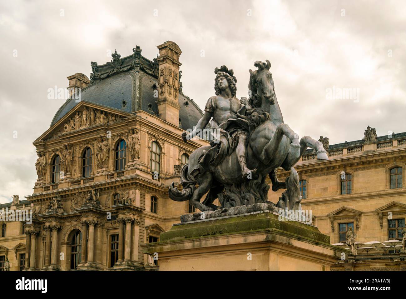 statue of Louis XIV at the court of Louvre museum in Paris, France