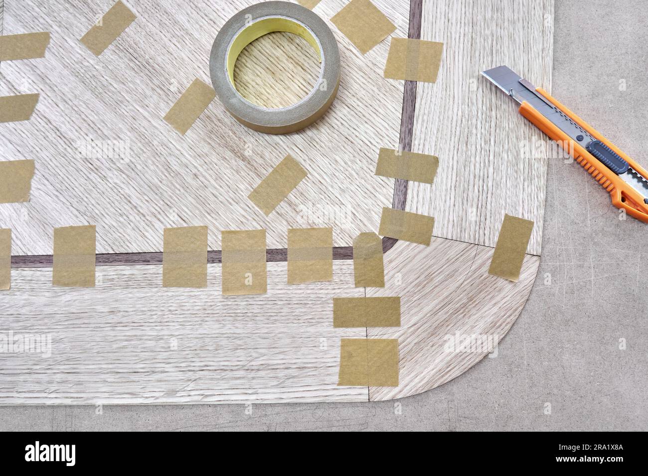 Jointed veneer with tape into canvas for table top of dining table with geometric pattern on workbench in workshop upper close view Stock Photo