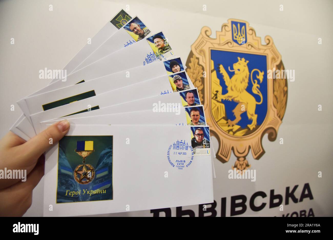 Stamps with the image of Ukrainian border guards killed by the Russian military, who were posthumously awarded the title of Hero of Ukraine, pasted on envelopes against the background of the coat of arms of the Lviv region. In honor of the killed Ukrainian border guards, the Russian army issued stamps. This happened on the initiative of the public organization 'Community in Action' and 'Ukrposhta'. The stamps were dedicated to eight Heroes of Ukraine, border guards received this title posthumously. The stamps were redeemed in the presence of two families of fallen Heroes of Ukraine - Roman Gak Stock Photo