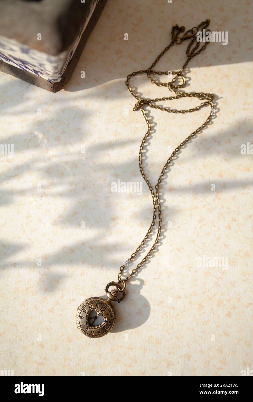 Old vintage pocket watch at a flea market. Beautiful lady watch on a chain in an antique store - Stock Image