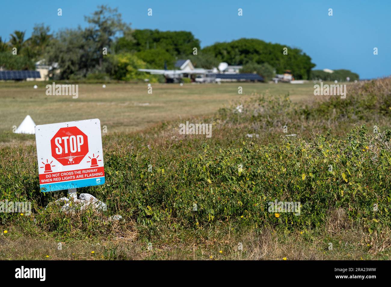 Red warning sign on edge of grass runway on Lady Elliot Island, Queensland Australia Stock Photo