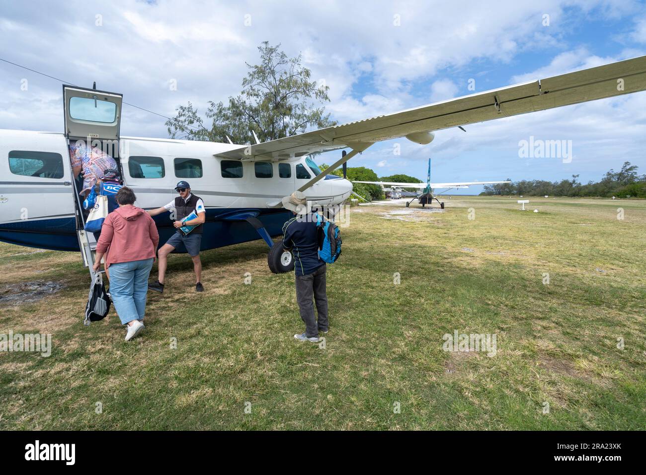 Tourist boarding Cessna Caravan 208 Sea Air on unpaved airfield, Lady Elliot Island, Queensland, Australia Stock Photo
