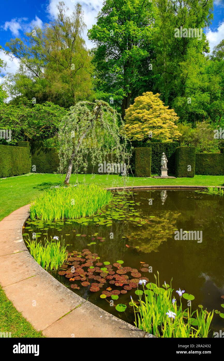 The peaceful tranquiity of the still waters inthe circular Pool Garden at Knightshayes Court, nr Tiverton, Devon, England, UK Stock Photo