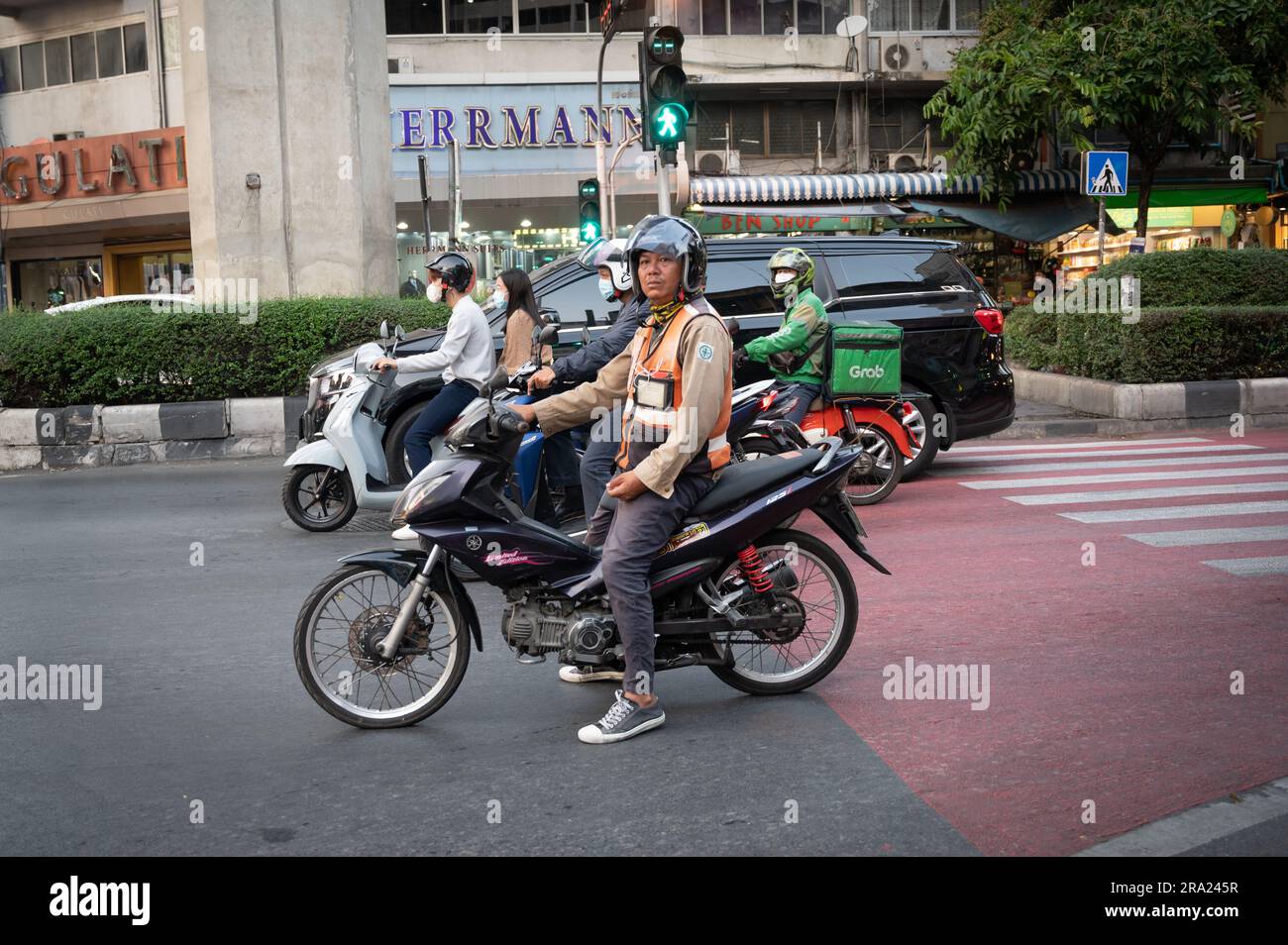 Moped riders and couriers in Bangkok, Thailand Stock Photo