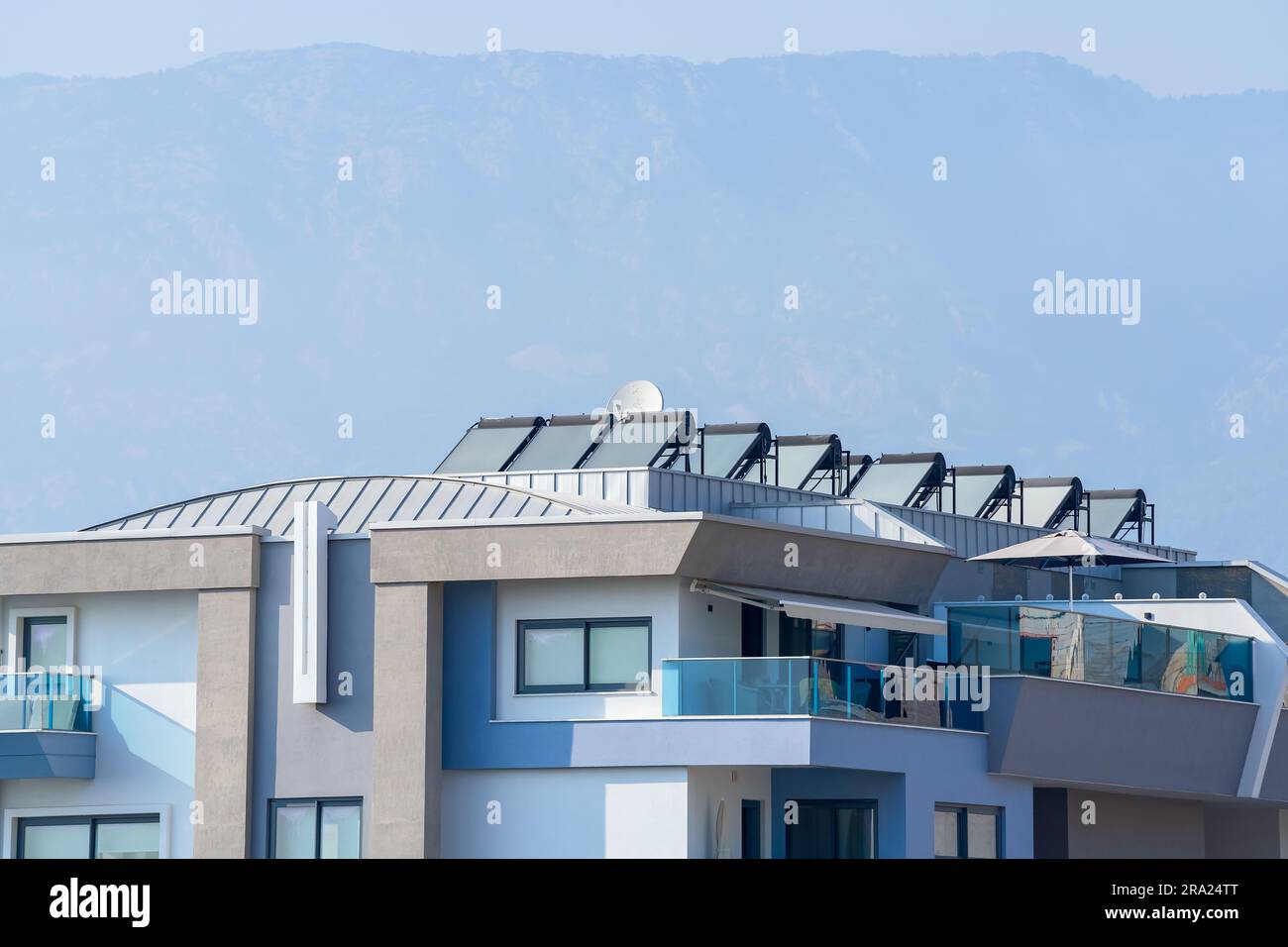 New modern apartment building. Details of modern urban architecture. A building with solar water heaters installed on the roof. Stock Photo