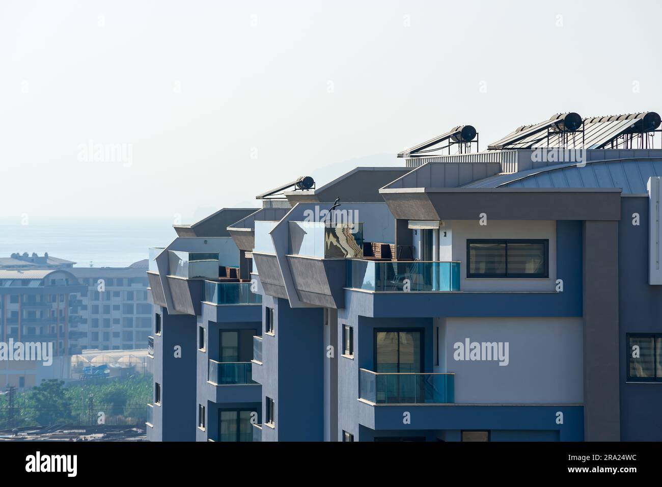 New modern apartment building. Details of modern urban architecture. A building with solar water heaters installed on the roof. Stock Photo