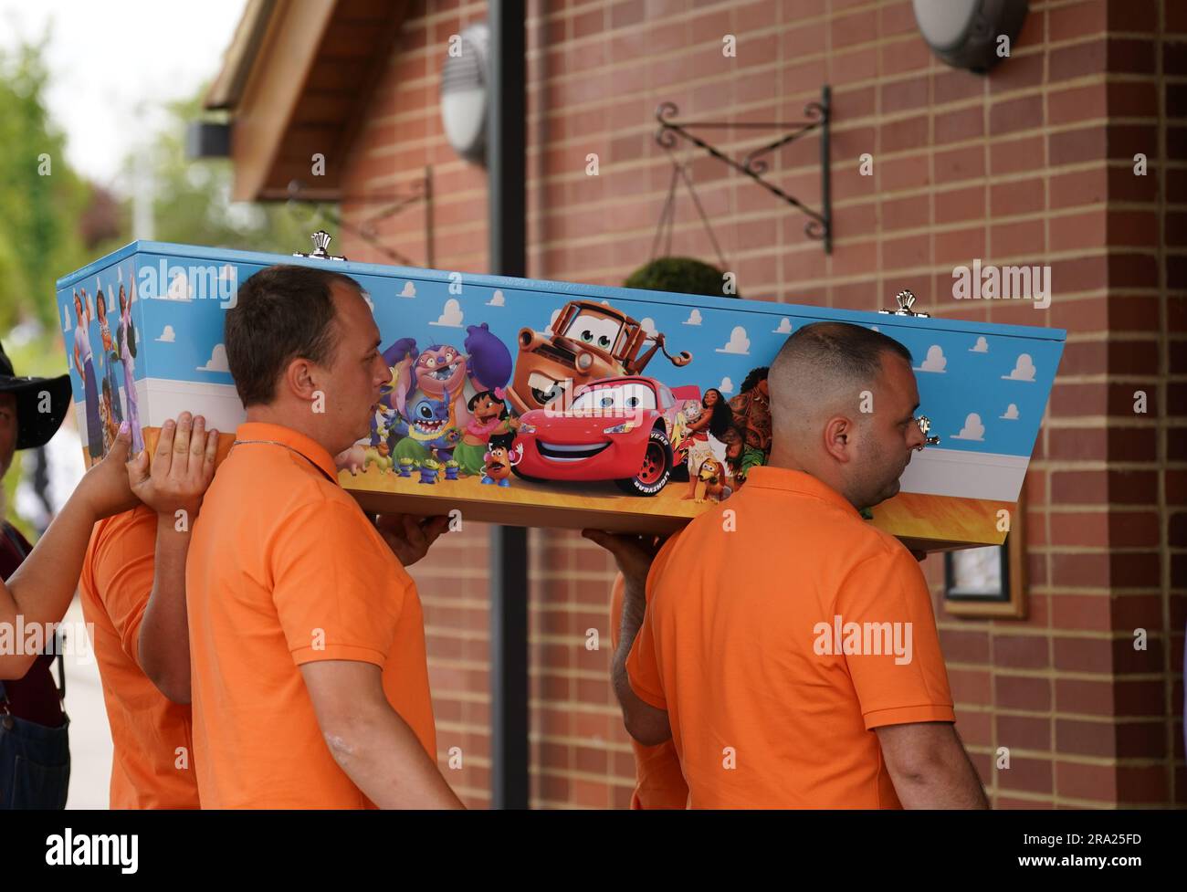 The coffin of Noah CoxLee, decorated with Disney cartoons is carried