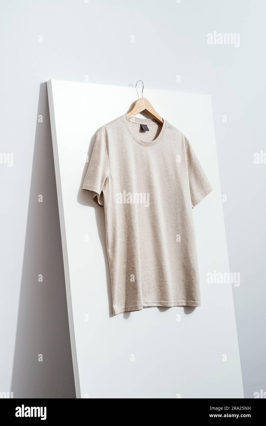 Blank beige t-shirt mockup, template on wooden hanger Stock Photo