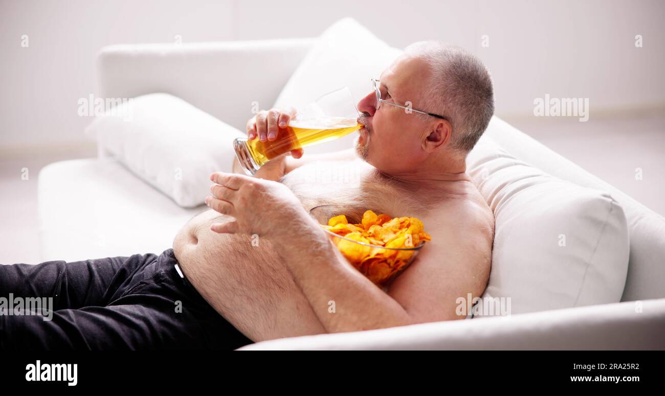 Overeating Junk Food, Drinking Beer And Watching TV Stock Photo Alamy