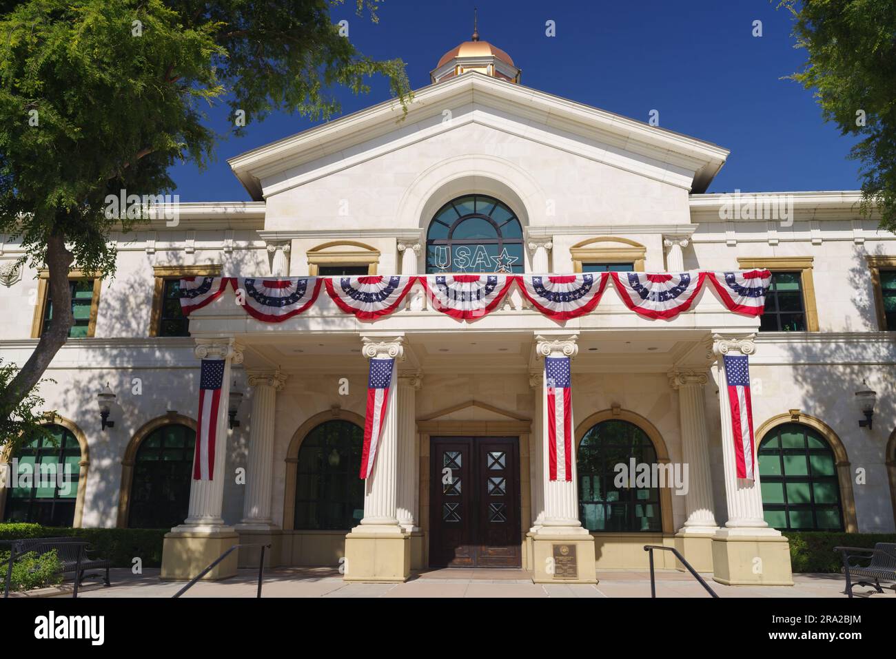 The Fillmore City Hall shown on a sunny afternoon, decorated with pleated fan flags, in