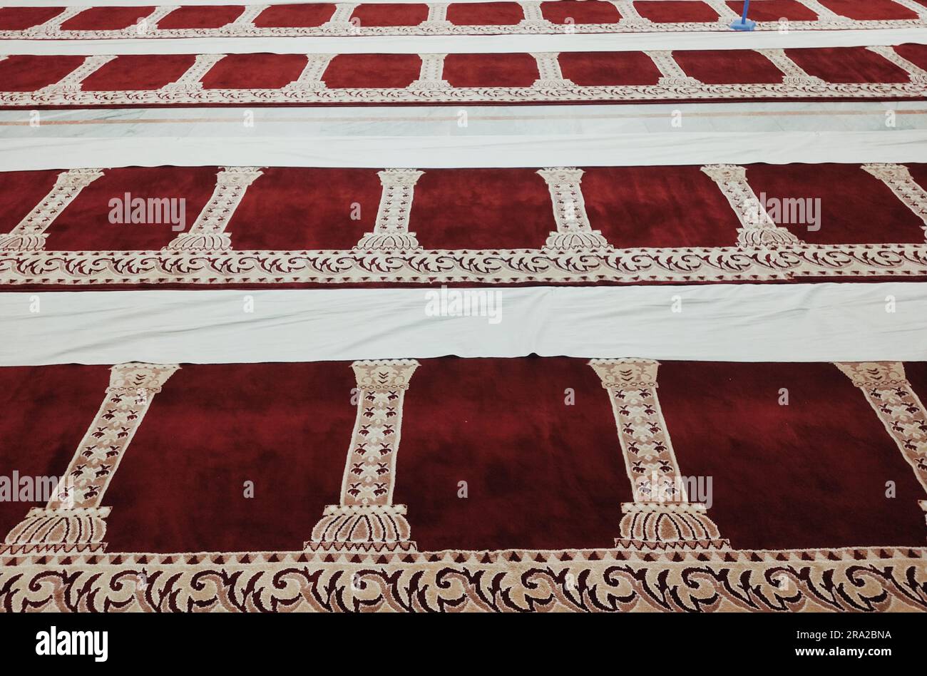 This stock photo features an image of a traditional Islamic mosque carpet with intricate geometric patterns Stock Photo