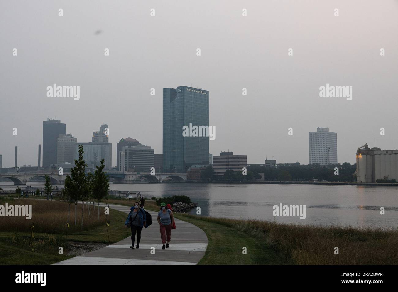 Toledo, United States. 28th June, 2023. People walk in Glass City Metropark as smog gathers as a result of Canadian wildfires in Toledo. Toledo, Ohio has been engulfed in smog as a result of the wildfires in Canada drifting south. Credit: SOPA Images Limited/Alamy Live News Stock Photo