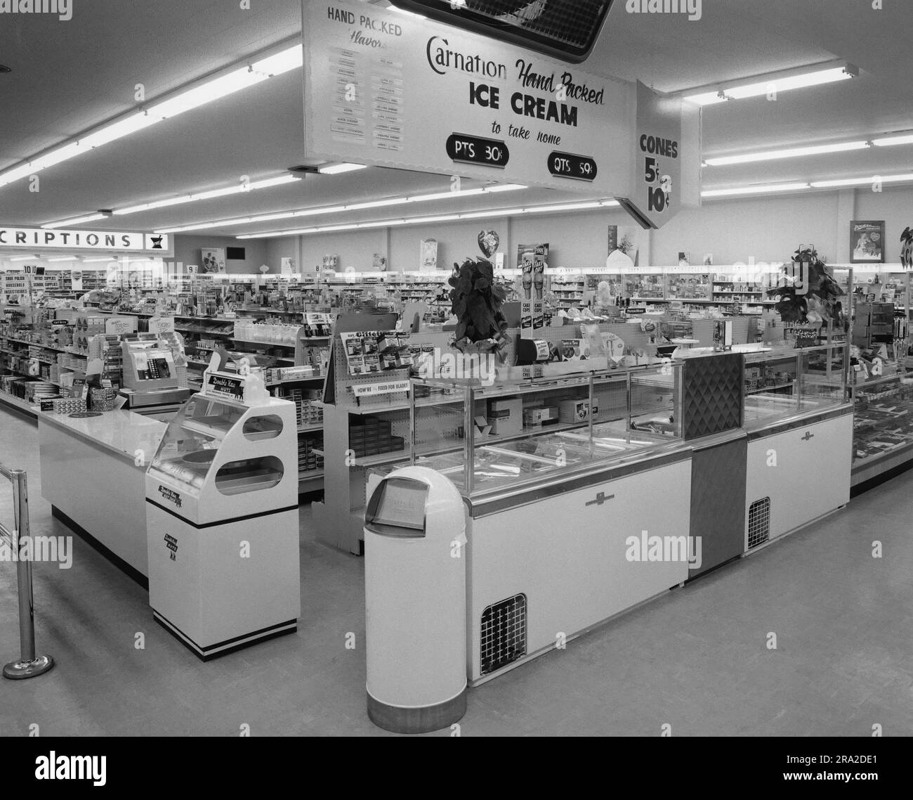 Inside of a drugstore showing the ice cream stand in the foreground. Ice cream cones, pints and quarts hand packed. Carnation ice cream Stock Photo