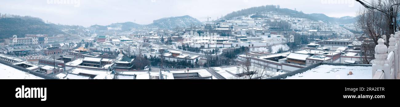 A panoramic view of a snow-covered city and mountains in the background Stock Photo