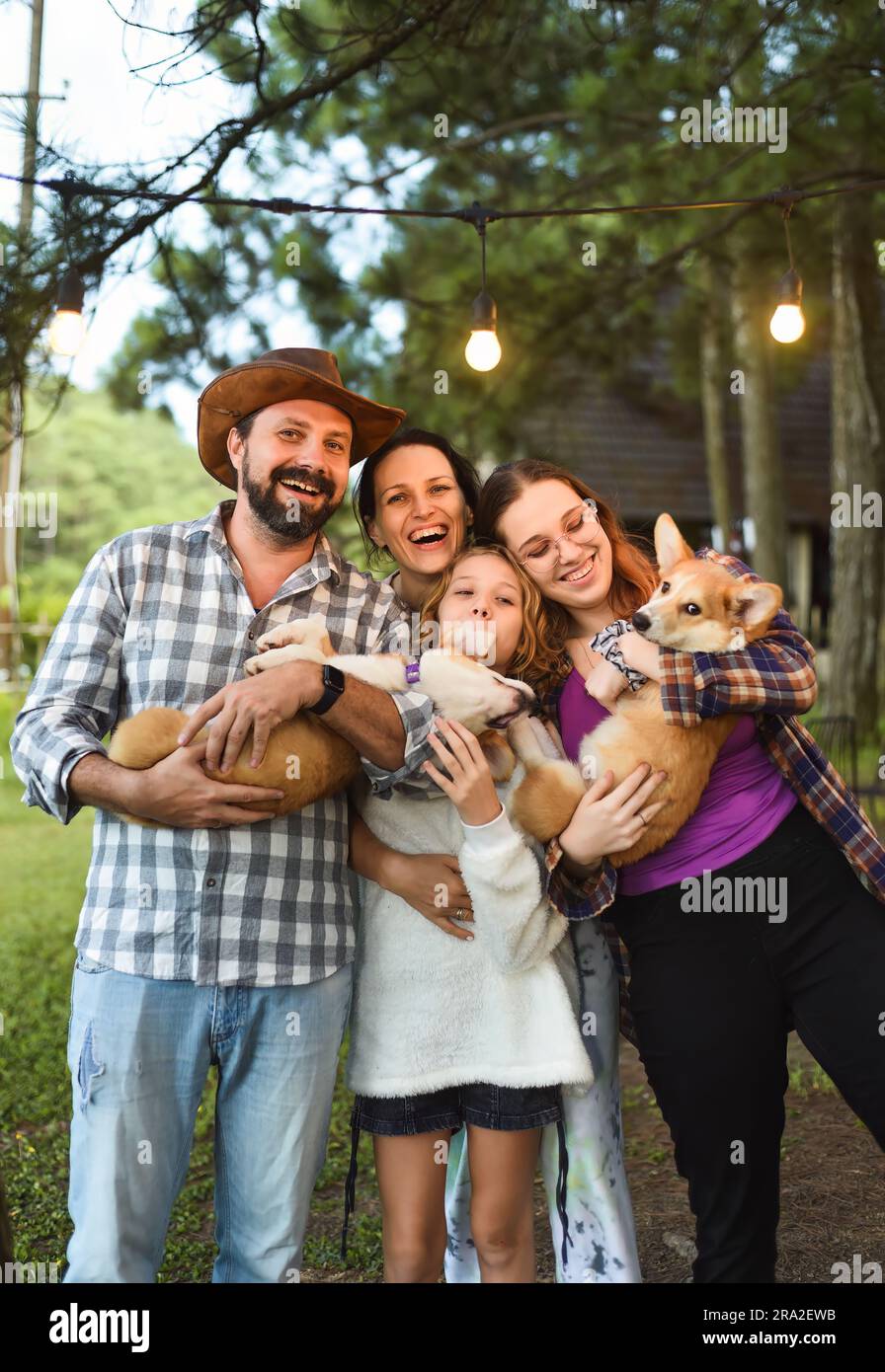 Family members father, mother and two daughters with corgi dogs in the forest Stock Photo