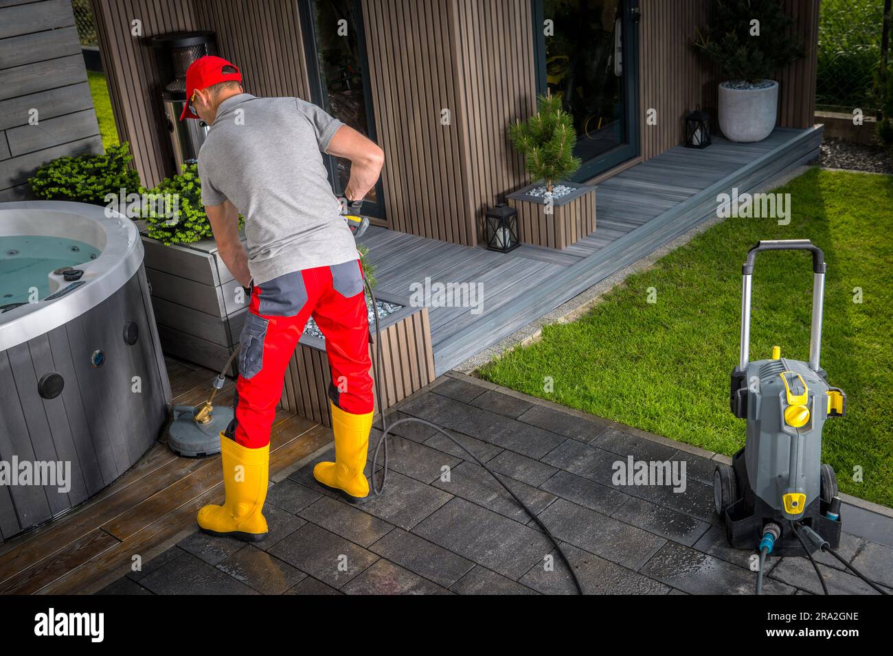 Caucasian Man in His 40s Pressure Washing Concrete Bricks Patio Using