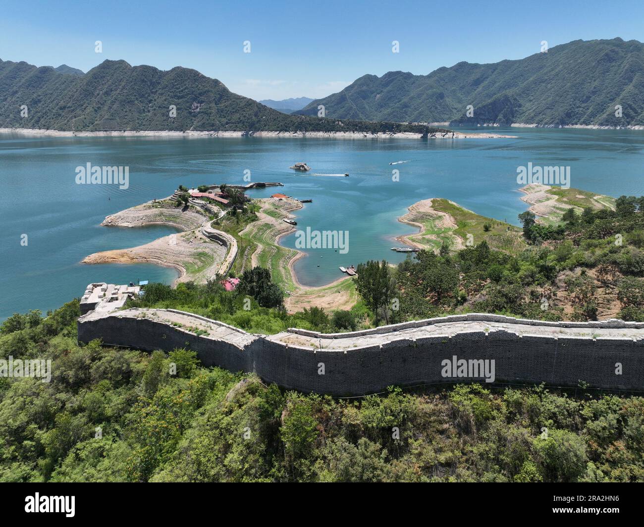 Qianxi. 29th June, 2023. This aerial photo taken on June 29, 2023 shows a partly submerged section of the Great Wall at Panjiakou reservoir in north China's Hebei Province. The Great Wall of China encounters the submersion by water when it meets the Panjiakou reservoir at the border of Qianxi County and Kuancheng Manchu Autonomous County in Hebei Province, creating a unique sight to behold. Credit: Mu Yu/Xinhua/Alamy Live News Stock Photo