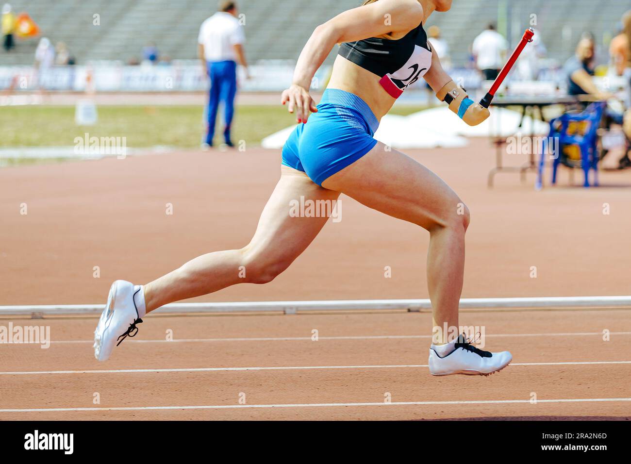 woman para athlete on prosthetic left hand running track stadium, summer para athletics championships Stock Photo