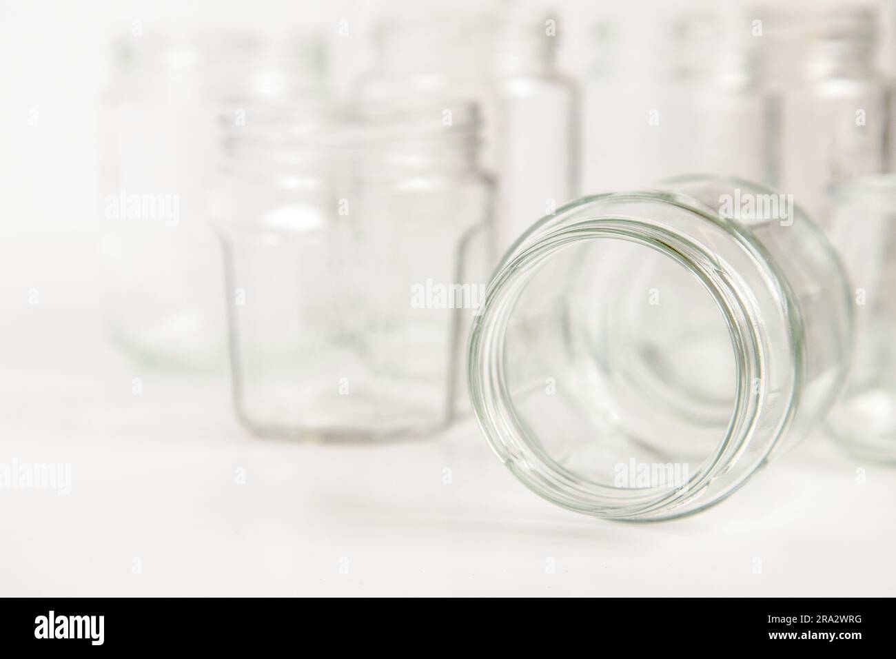 Assorted set of glass containers without lids on white background, recycling. Concept of second life to materials, various uses for glass vials. Stock Photo