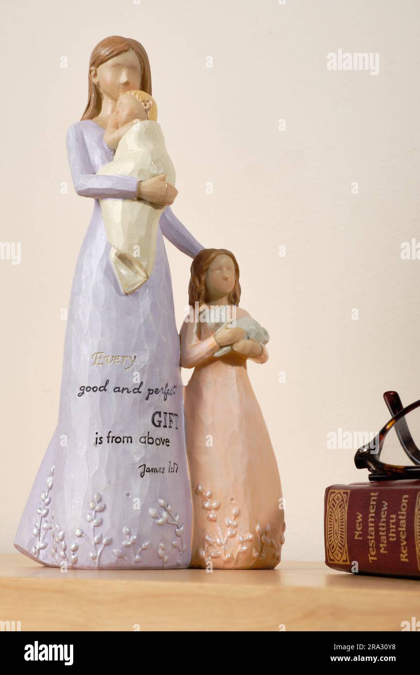 Christian themed ceramic ornament of a mother with her daughter and baby, inscibed with 'Every good and perfect gift is from above James 1:17'. Stock Photo