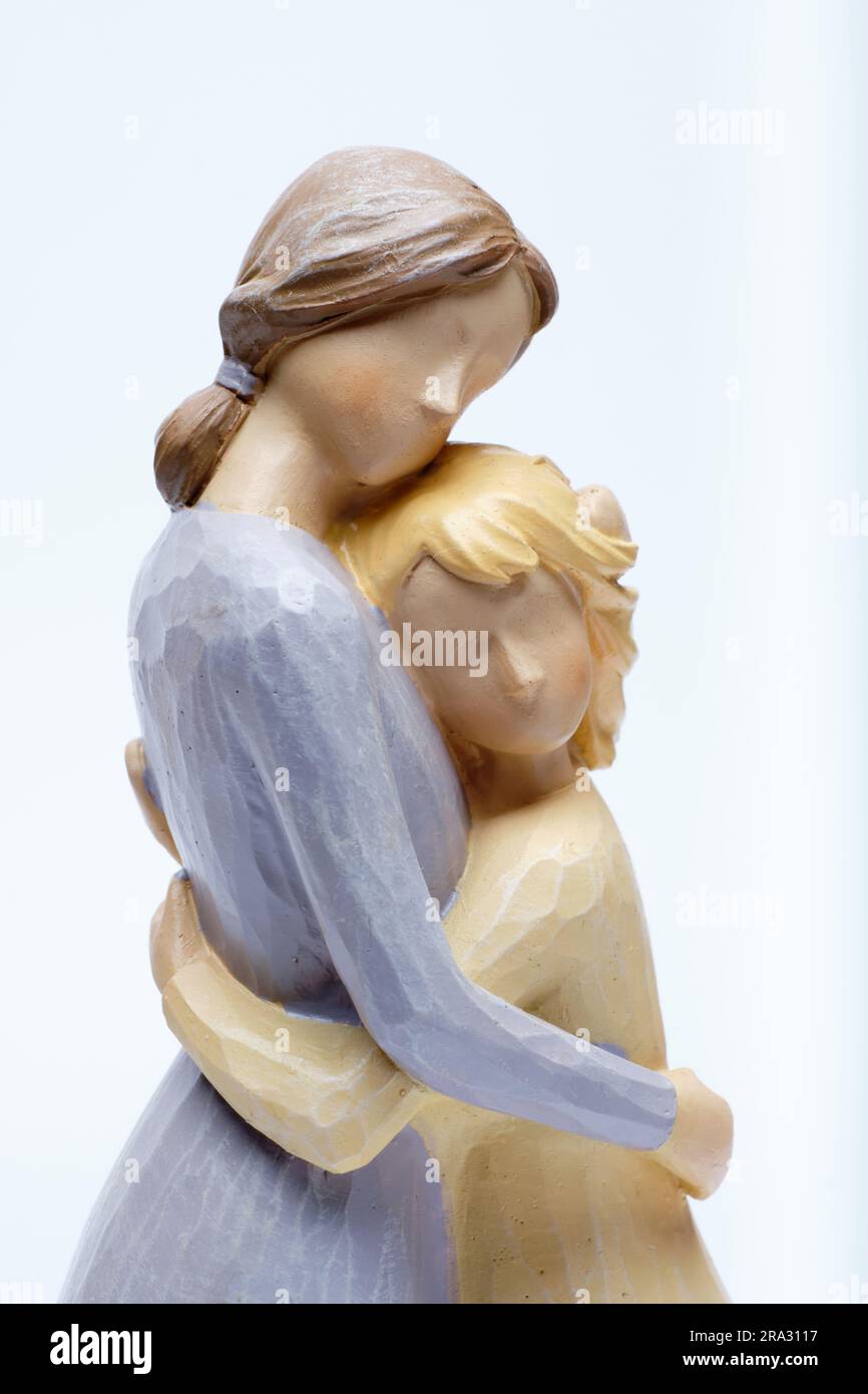 Christian themed ceramic ornament close-up of a mother hugging her daughter against a white background. Stock Photo