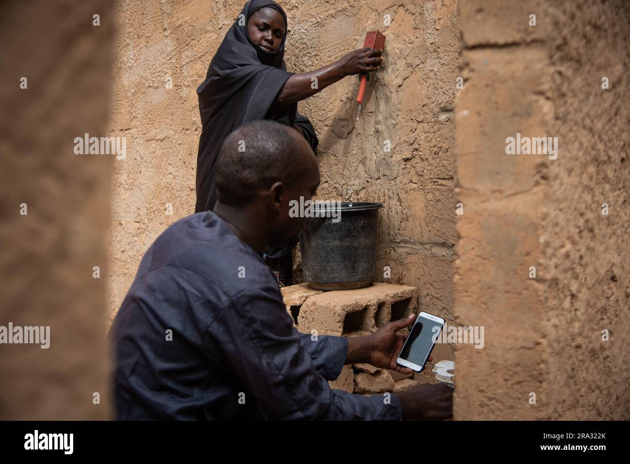Nicolas Remene / Le Pictorium -  Prepaid meters and mobile application in Niger -  29/5/2020  -  Niger / Niamey / Niamey  -  In the Goudel Maourey district of Niamey in Niger, 'smart' water meters have been installed, enabling each family to pay for its water consumption as it occurs, using a mobile phone and an application. This type of prepaid meter allows local residents to regulate their consumption according to their income. This makes it possible to offer access to drinking water at home at a lower cost, with a prepayment system adapted to the irregular incomes of a large proportion of d Stock Photo