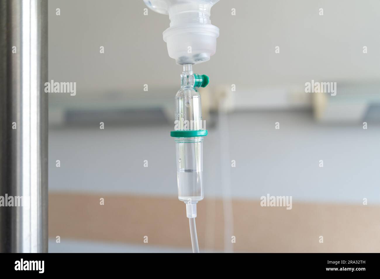 Infusion bag with drop counter on a IV stand pole or bottle hanger. Intravenous therapy, hanging bag of medicine for a patient in a hospital room. Stock Photo