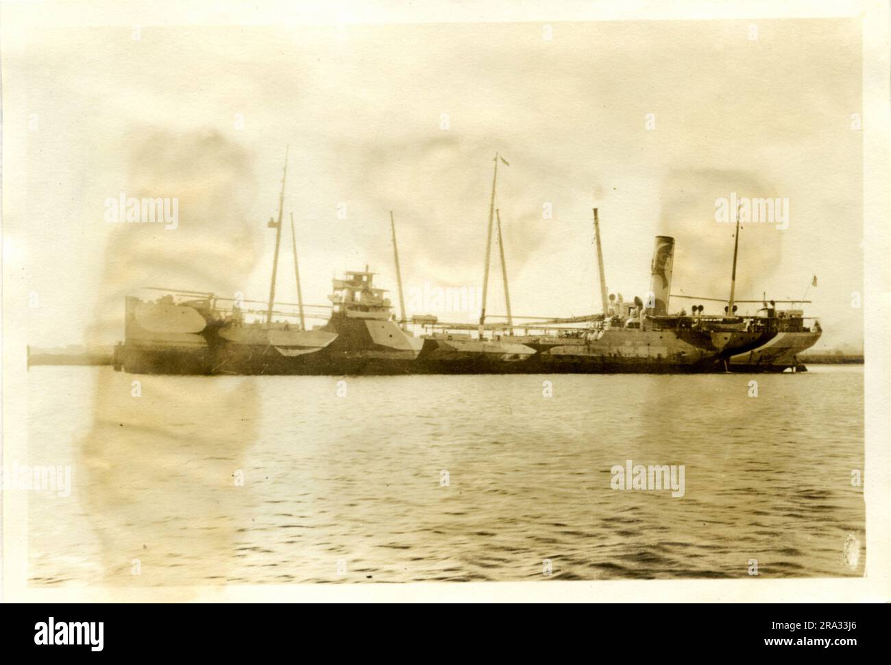 Photograph of the Port View of the SS Socony. Photograph of port view. Date: - Sept. 12th., 1918. Photograph of S. S. Socony. Nationality: - American. Tonnage: - 3663. Captain: - T. Jonassen. Owners: - Std. Oil Co. Where From: - Wilmington, N. C. Destination: - San Pico, Mexico. Where Photographed: - Charleston, S. C. Sixth Naval District. By Whom Photographed: - J. B. Dearborn. Date: -Aug. 10th., 1918. Where Camouflaged: -New York. Date: - March 10th., '18. By Orders of the U. D. U. S. Gov't. Type of ship: - Oil Tanker. Length: - 320 ft., Beam: -46.22 ft., Draft: - 24 ft. Starboard unobtainab Stock Photo