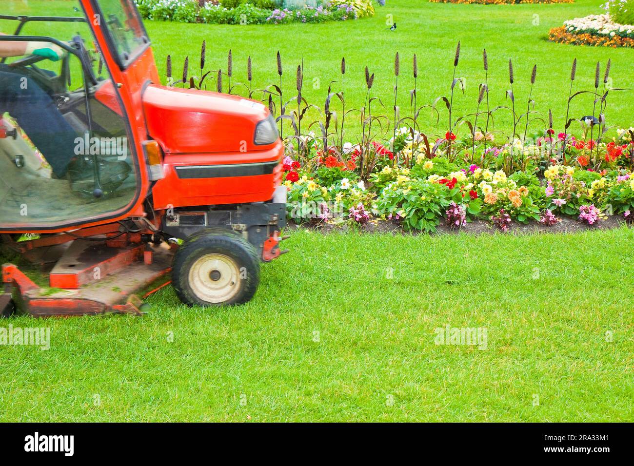 Ride on lawn mower cutting grass Image with copy space Stock Photo
