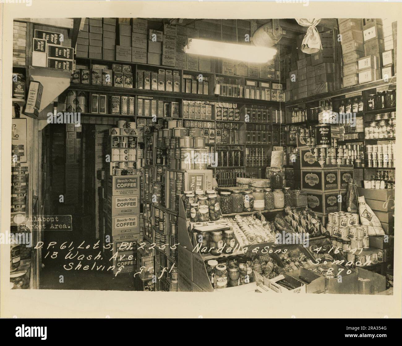 Photograph of interior room view of lot 5, bl. 2255 - Nordella & Sons, 13 Wash. Ave, shelving on ground floor. Depicts interior room view of Nordella & Sons with stacked goods for sale with sgnange from Beech-Nut Coffee. Stock Photo