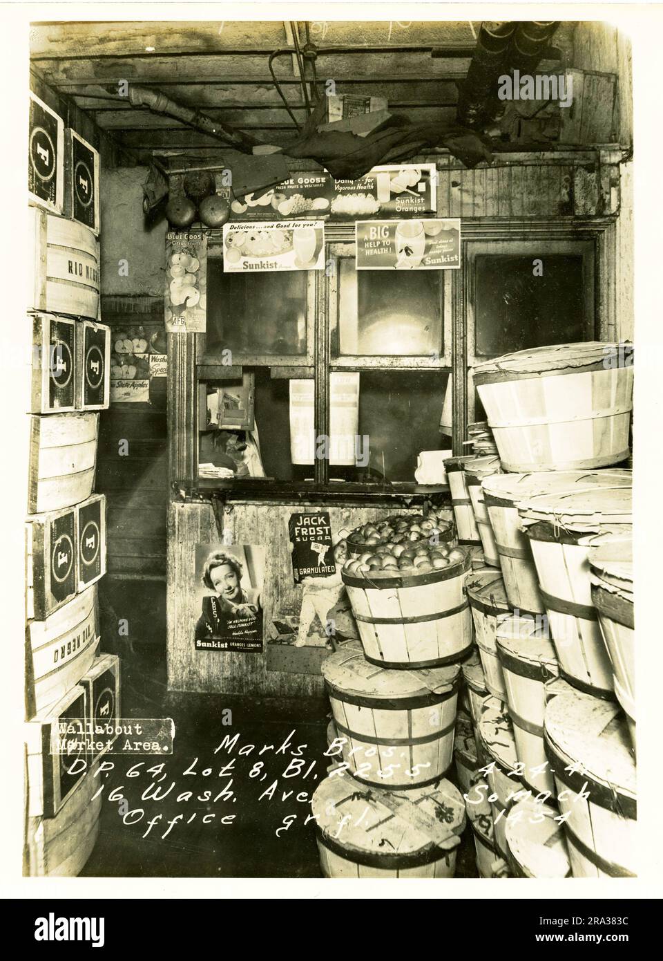 Photograph of interior Wallabout Market, D.P. 64, Lot 8, Bl. 2255, 16 Washington Ave. Marks Bros. Office Gr. Fl.. View of office partition surrounded by crates and apple bushels, with promotional posters featuring Hedda Hopper for Sunkist, Jack Frost sugar, from negative 1454.. Stock Photo