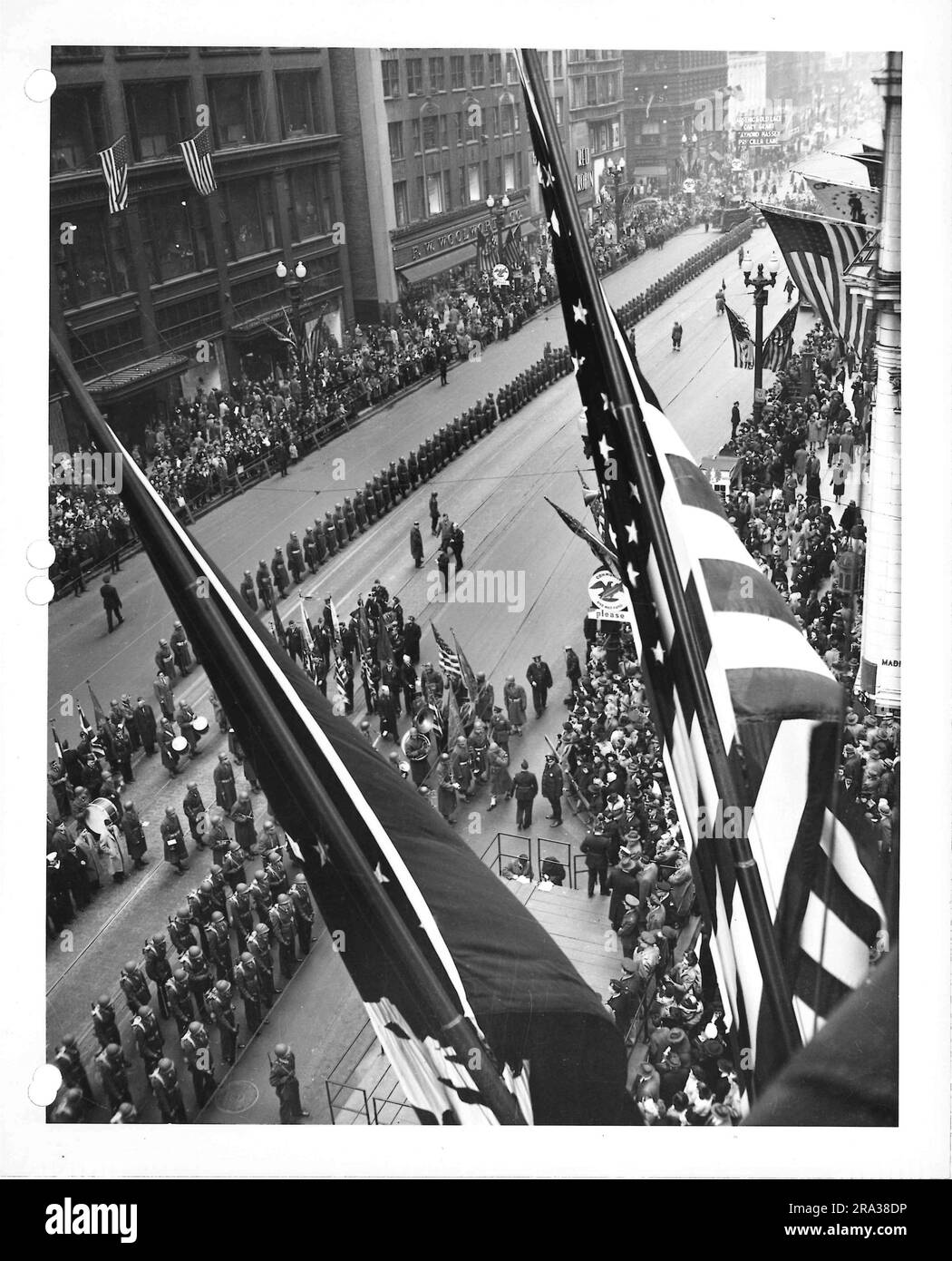 Photograph of Military Parade - Band in Front of Crowd and Flags - F.W. Woolworth Building in Background. Stock Photo