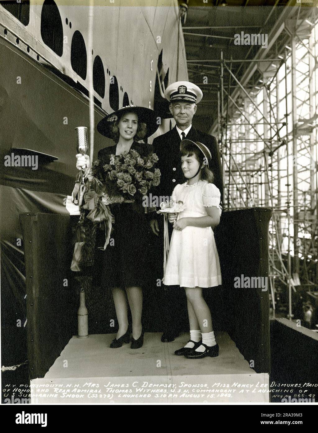 Mrs. James C. Dempsey, Sponsor, Miss Nancy Lee Dismukes, Maid of Honor, and Rear Admiral Thomas Withers. Original caption: Mrs. James C. Dempsey, sponsor, Miss Nancy Lee Dismukes, Maid of Honor, and Rear Admiral Thomas Withers at launching of U.S. Submarine Snook, Navy Yard, Portsmouth, NH.. 1942-08-15T00:00:00. Stock Photo