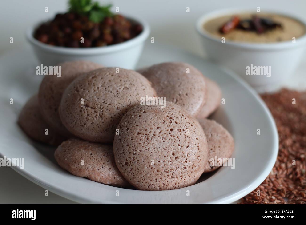 Navara rice idly served black chickpea curry. Steamed savoury rice cake made by a batter of fermented de husked black lentils and navara rice. Navara Stock Photo