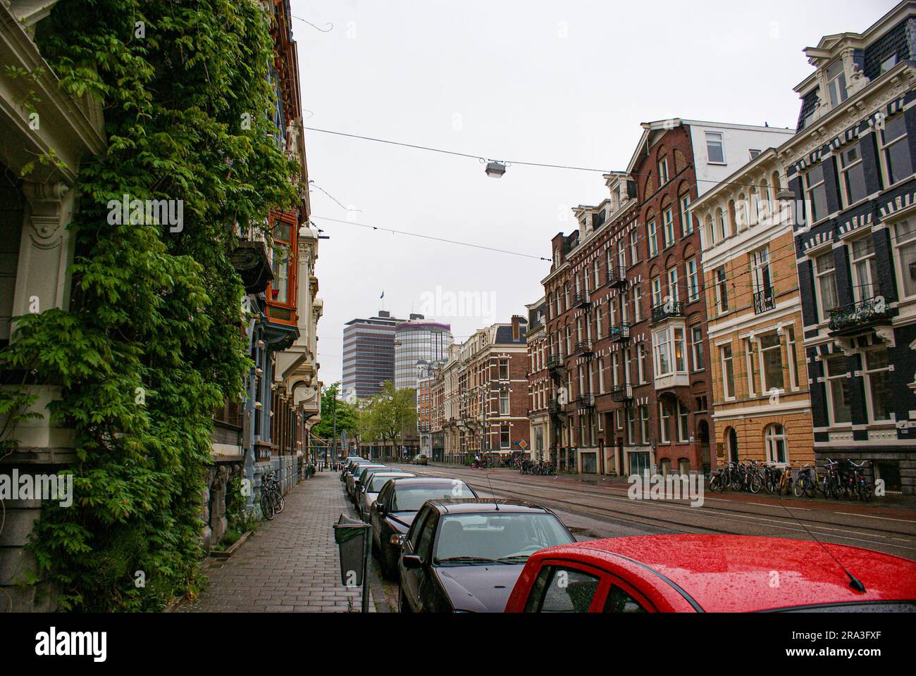 a city street with cars parked on the side of a building Stock Photo ...