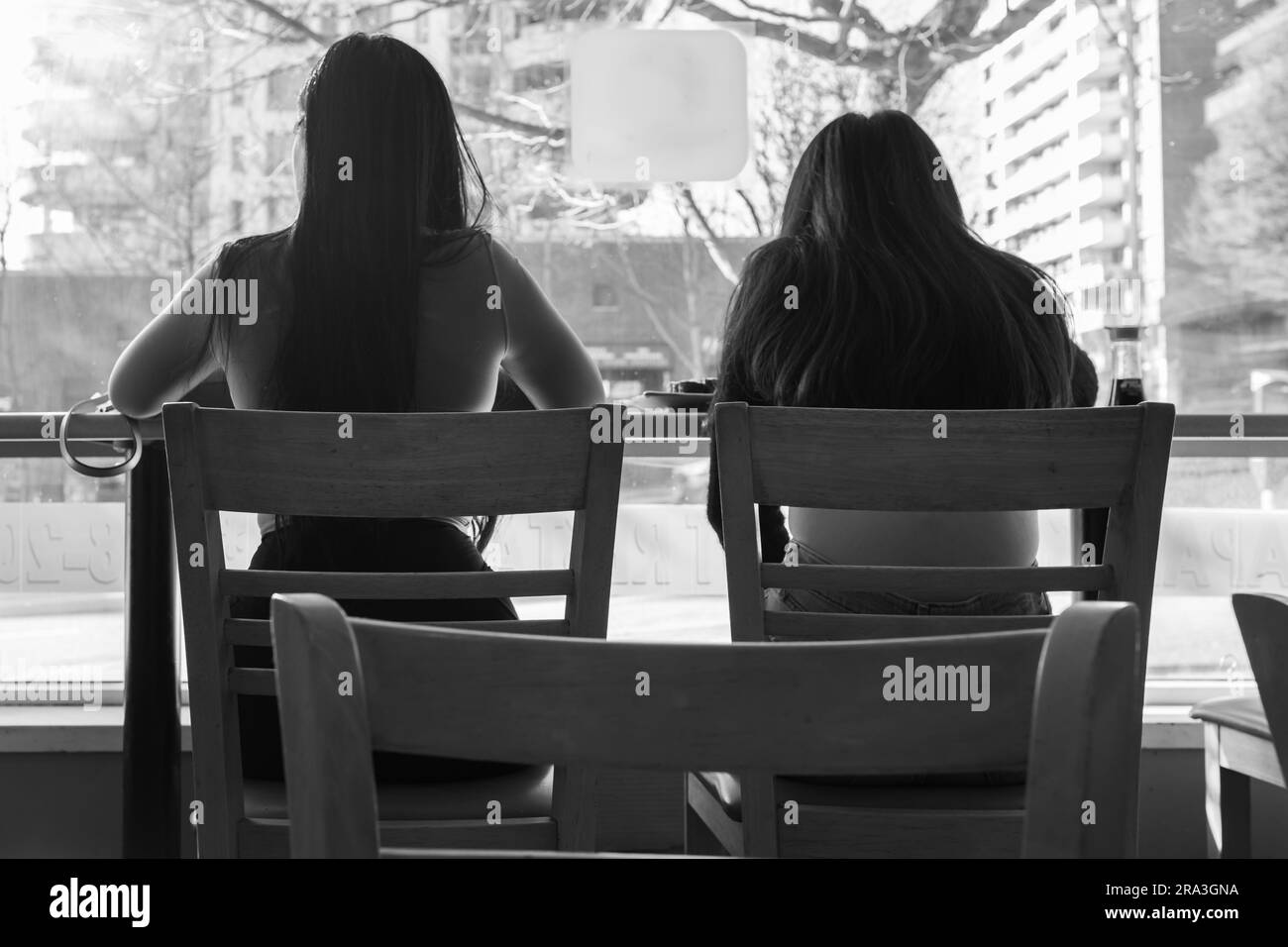 Beautiful Asian women enjoy chatting, eating in the cafe or restaurant. Girl's activities concept. Two young girls at a lunch in a restaurant. Female Stock Photo